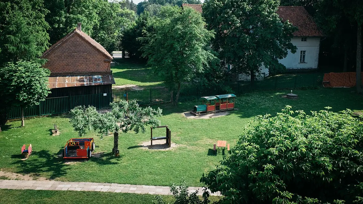 Exterior of a Swiss daycare facility with playground area, modern architecture, documentary photography