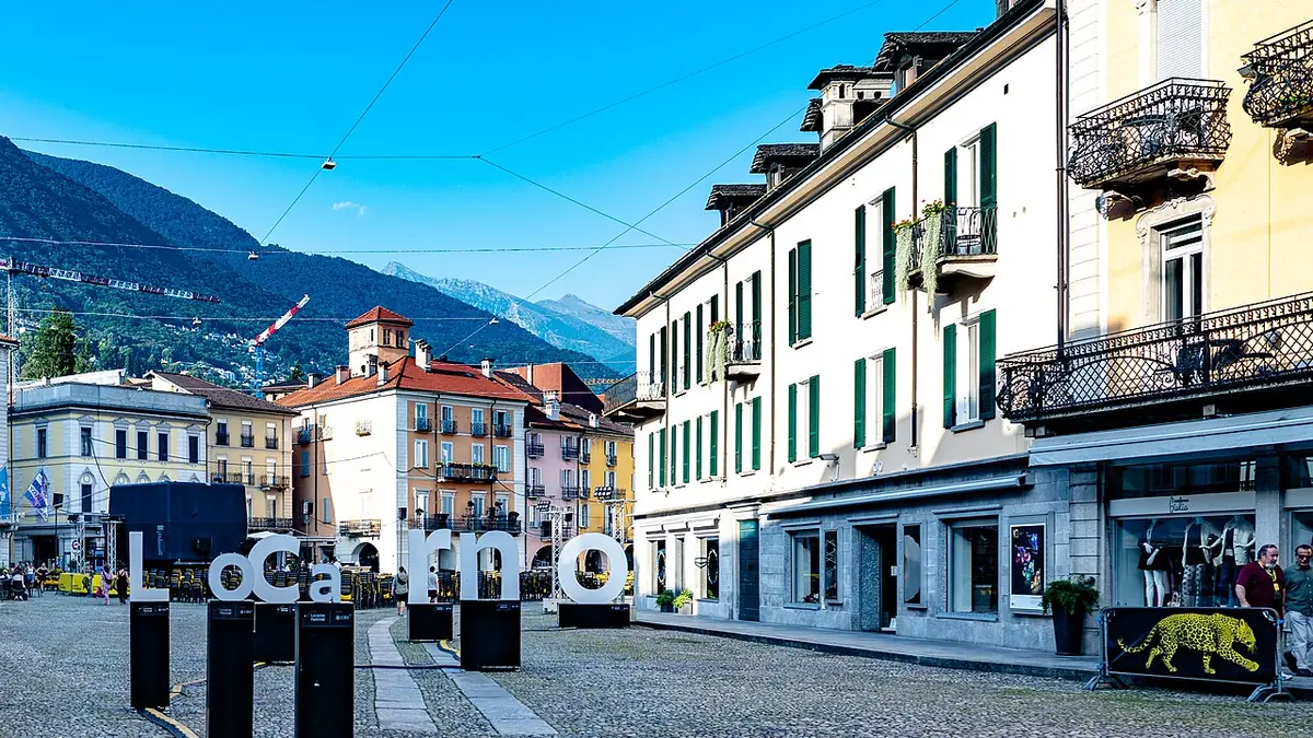 Sonnige Straße in Bellinzona mit Menschen im Schatten während einer Hitzewelle